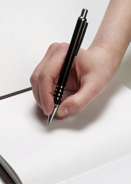 Hand with pen on empty page — Stock Photo, Image