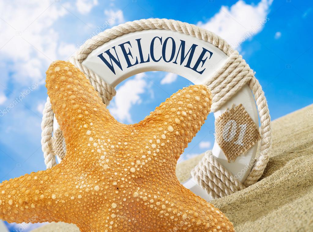 Starfish and welcome sign on beach