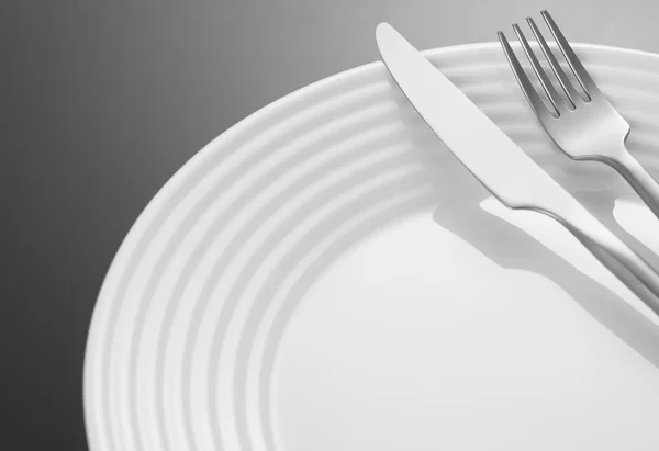 Silverware and plate on black background — Stock Photo, Image