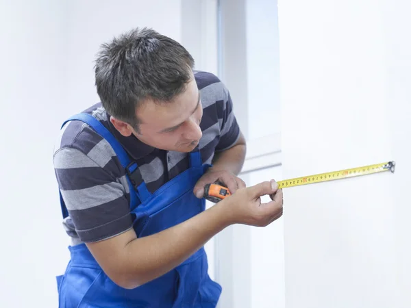 Handwerker misst die Wand — Stockfoto