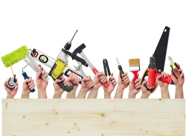 Hands holding tools and wood board — Stock Photo, Image