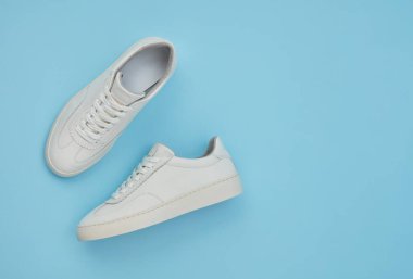 Mavi arkaplanda beyaz klasik ayakkabılar