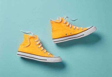 Mavi arkaplanda sarı tuval ayakkabılar