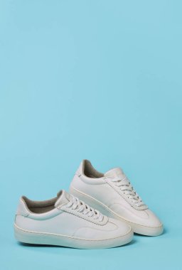 Mavi arkaplanda beyaz klasik ayakkabılar