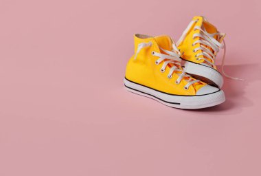 Pembe arka planda sarı tuval ayakkabılar