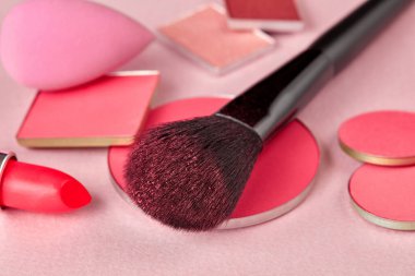 Fırça, yüz pudrası, ruj ve sünger.