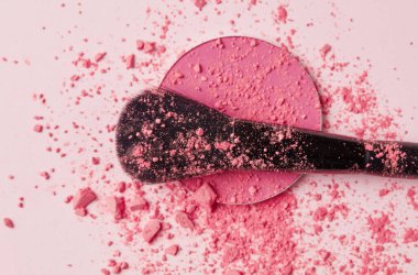 Pembe arka planda fırça ve toz makyajı