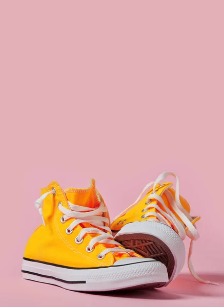 ピンクの背景に黄色のキャンバスの靴 — ストック写真