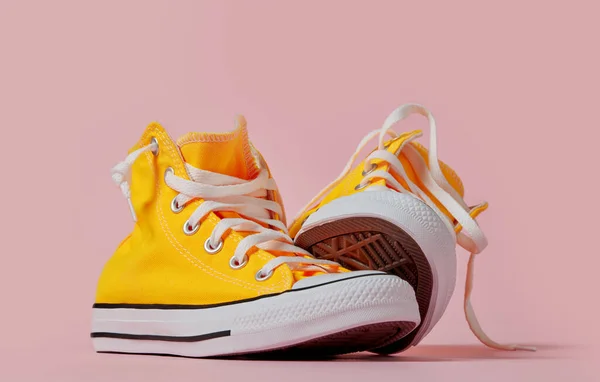 ピンクの背景に黄色のキャンバスの靴 — ストック写真