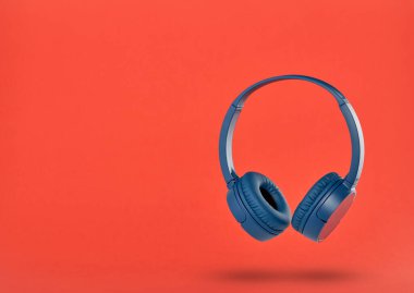 Kırmızı arkaplanda kablosuz mavi kulaklık