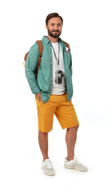 バックパックと白い背景に写真カメラを持つ陽気な男 — ストック写真