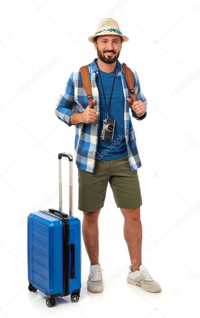 Cheerful man with backpack, suitcase and photo camera on white background