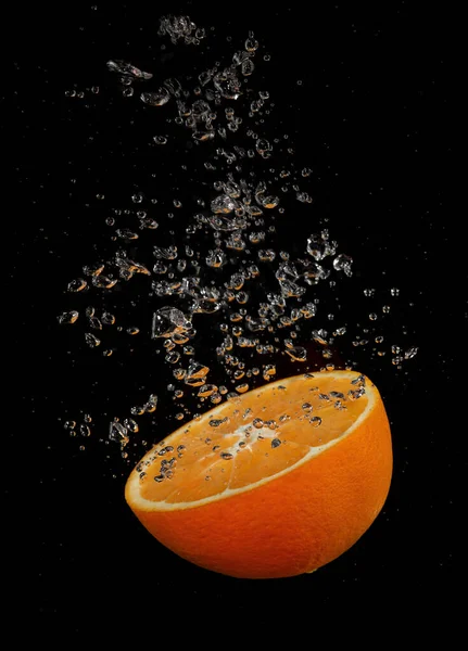 Orange splashing in water on a black background