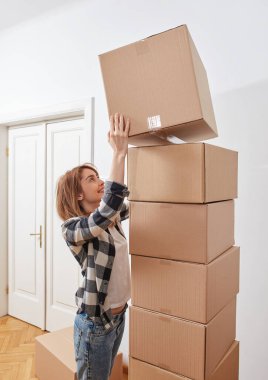 Karton kutuları olan genç bir kadın.
