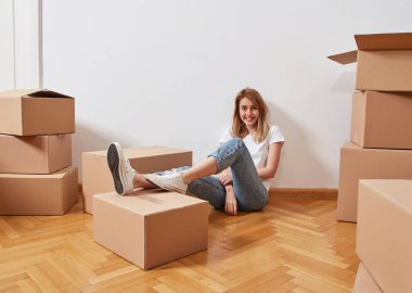 Karton kutuları olan genç bir kadın.