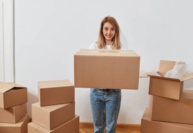 Karton kutuları olan genç bir kadın.