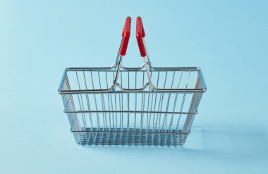 Mavi arka planda boş alışveriş sepeti