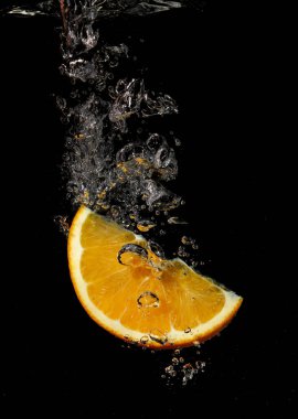 Siyah arkaplanda süzülen portakal.