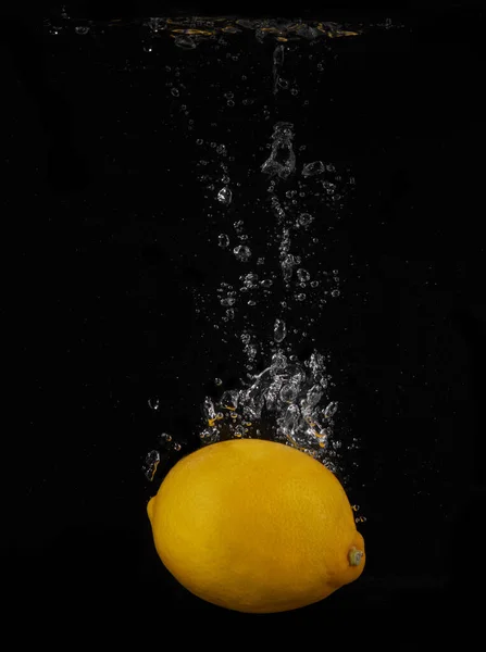 Lemon splashing in water on a black background