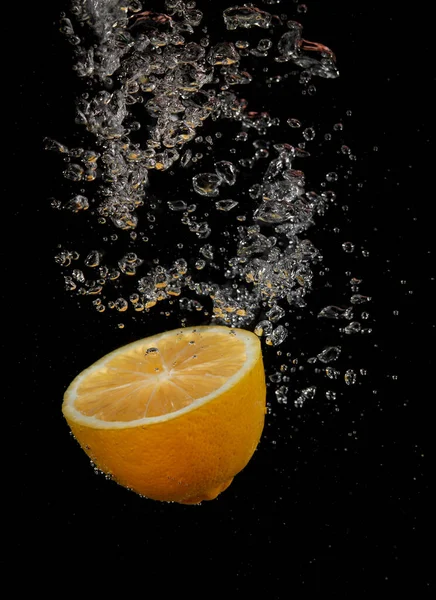 Lemon splashing in water on a black background