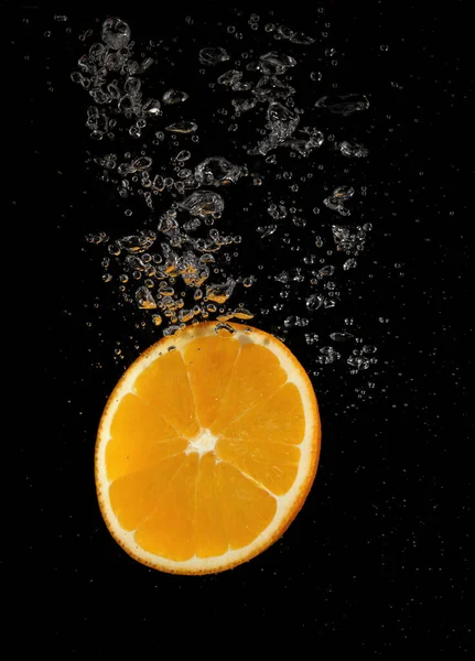 Éclaboussures Orange Dans Eau Sur Fond Noir — Photo