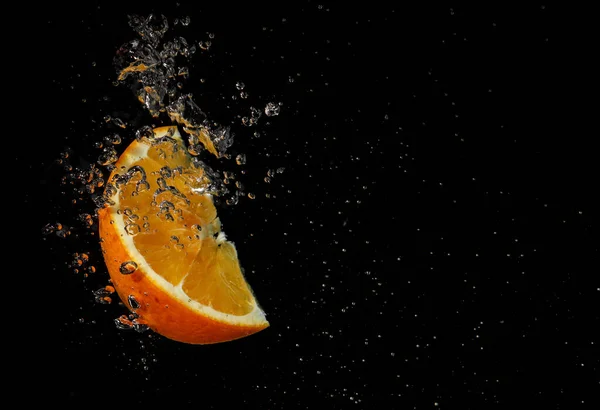 Orange Plätschert Wasser Auf Schwarzem Hintergrund — Stockfoto