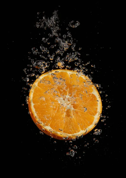 Orange Plätschert Wasser Auf Schwarzem Hintergrund — Stockfoto