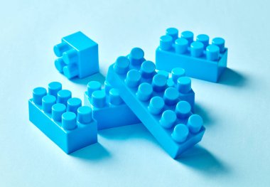 Blue toy bricks on blue background clipart