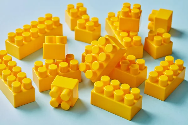 Plastik Gelbe Spielzeugklötze Auf Blauem Hintergrund — Stockfoto