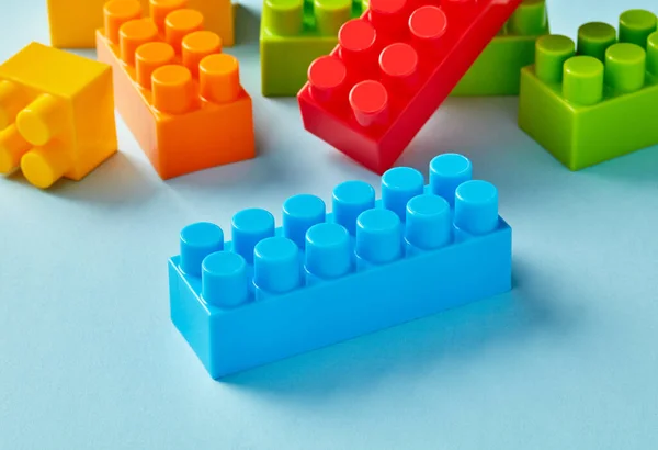 Plastic toy blocks on blue background