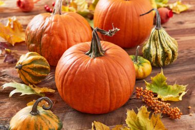 Ahşap arka planda balkabakları ve yapraklar