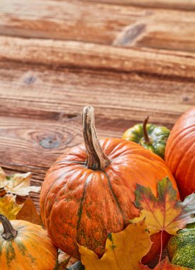 Ahşap arka planda balkabakları ve yapraklar