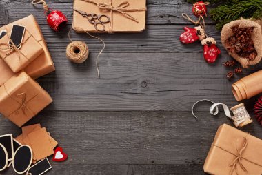 Noel hediyeleri ahşap bir masada, şenlik süslemelerinin yanında duruyor.