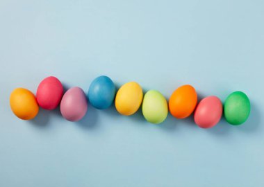 Pastel mavi arka planda renkli paskalya yumurtaları