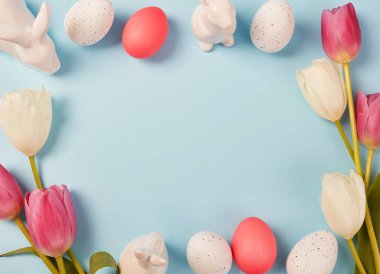 Paskalya çerçevesi lalelerle, tavşan heykelcikleriyle ve süslü yumurtalarla