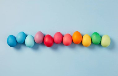 Satır mavi arka plan üzerinde renkli Paskalya yortusu yumurta