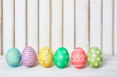 Ahşap masada süslü paskalya yumurtaları.