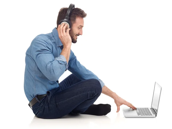 Homem com fones de ouvido e laptop — Fotografia de Stock