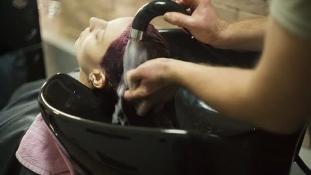 Парикмахер моет бабам голову — стоковое видео