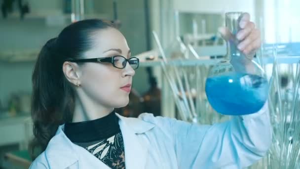 Femme secoue flasque dans un laboratoire — Video