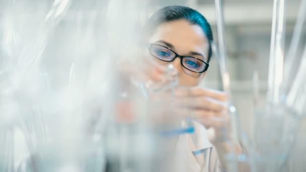Mujer trabajando con matraz en un laboratorio — Vídeo de stock