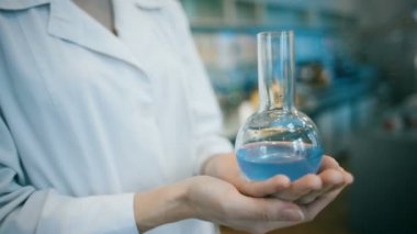 Bir laboratuvar şişesi tutan kadın