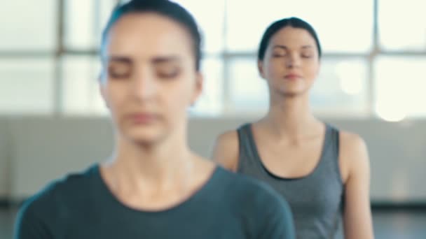 Mujeres jóvenes meditando en el interior — Vídeos de Stock