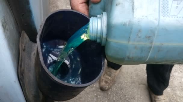 Rural man fills a car diesel engine from a canister — Stock Video