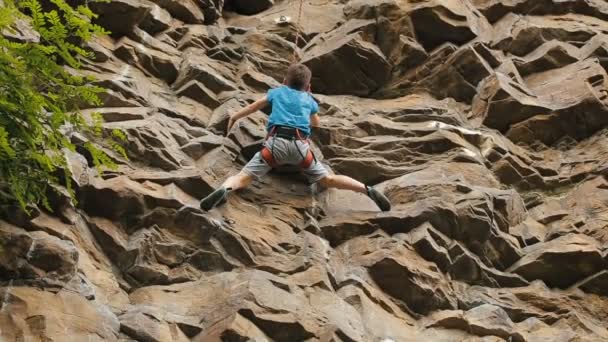 Garçon escalade sur un rocher — Video