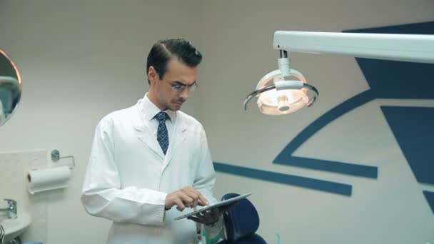 Dentista che utilizza tablet presso la clinica dentale — Video Stock