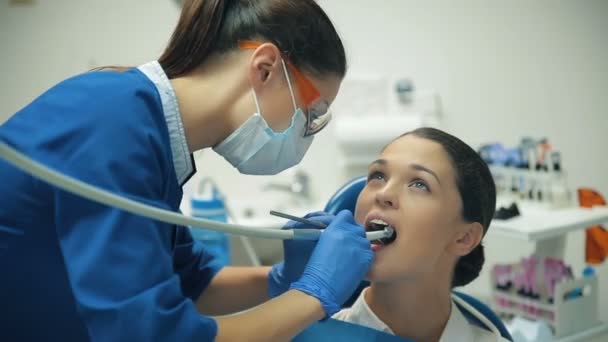 Žena zachází zuby u zubaře