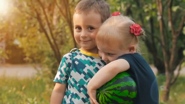 Літлє дівчинка обіймає і ніж цілує хлопчика — стокове відео