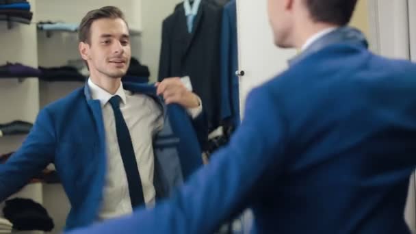 Hombre Sonriente usando una chaqueta en la tienda — Vídeos de Stock