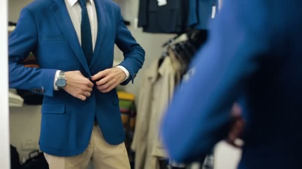 Hombre guapo usando traje en la tienda de ropa — Vídeo de stock